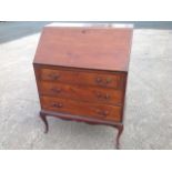 A mahogany bureau with fallfront enclosing an interior