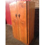 A 50s walnut wardrobe/compactum, with shaped crossbanded doors enclosing an interior