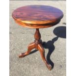 A circular mahogany occasional table, the moulded top supported on leaf carved baluster column