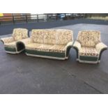A floral brocade button upholstered three-piece suite, with loose cushions, raised on casters. (3)