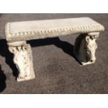 A rectangular composition stone bench, the egg & dart moulded seat on horsehead supports.