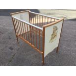 A childs cot, having rounded head and tailboard