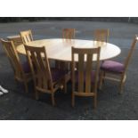 A large contemporary oval oak dining table and chair set.