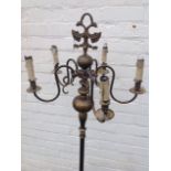 A brass candelabra standard lamp with five scrolled branches supporting candles