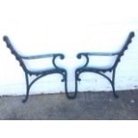 A pair of cast iron bench ends of scrolled design, with wood inserts to arms. (2)