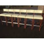 A set of six cream upholstered bar stools.