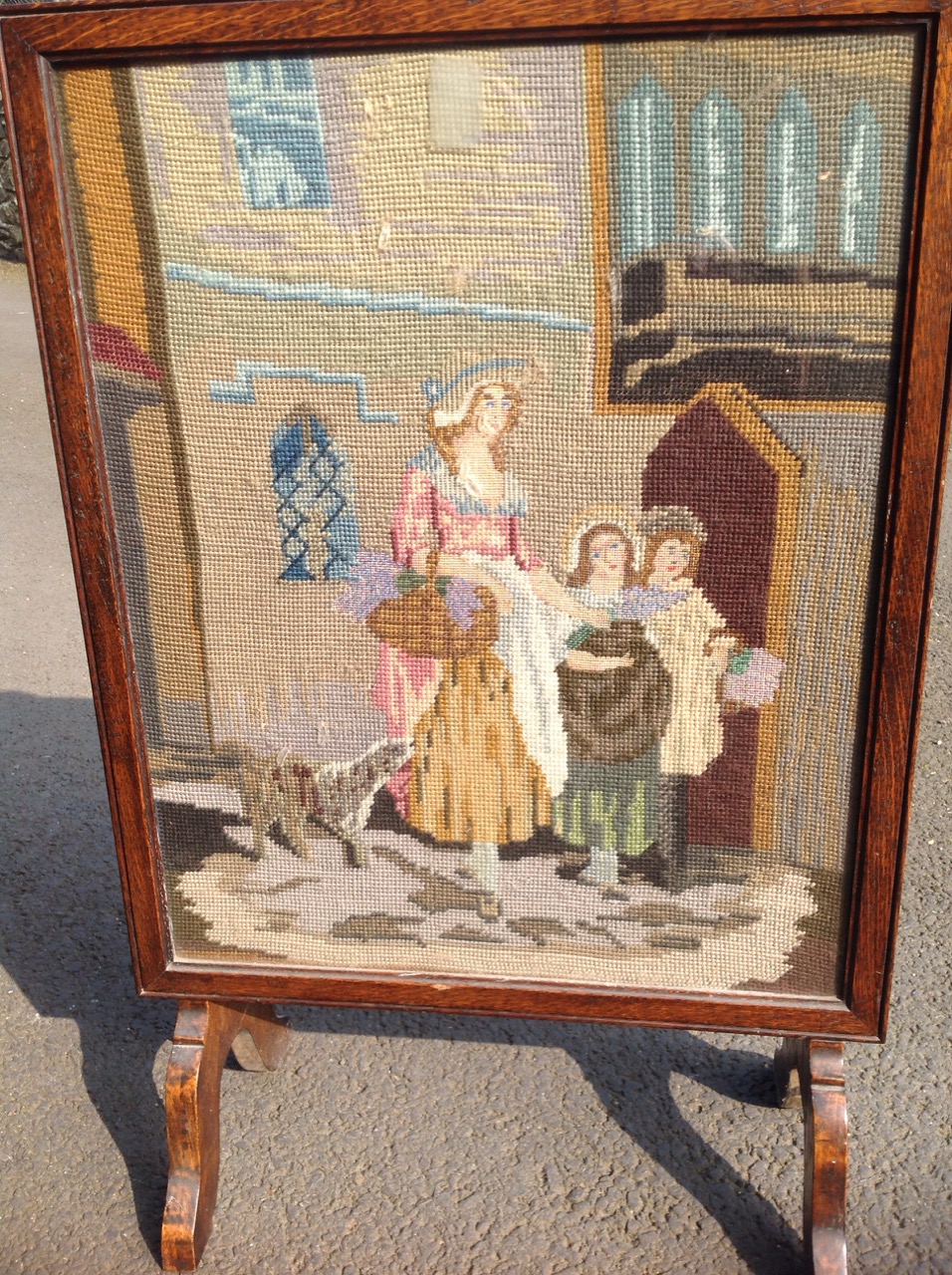 An oak firescreen, the woolwork tapestry panel depicting a mother with her children & dog. - Image 2 of 3