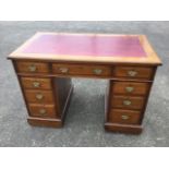 An Edwardian mahogany kneehole desk, the moulded top with skiver above three frieze drawers