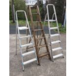 Two sets of aluminium stepladders, each having ribbed rungs; and a set of folding wooden steps. (3)