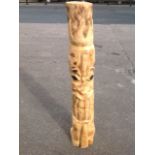 A chainsaw totem pole, cut from a pine tree trunk, with scorched detailing and natural decking oil