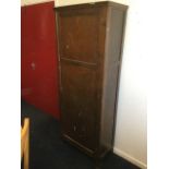 A stained cupboard with moulded cornice above a panelled door mounted with bakelite handle