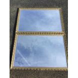 A pair of rectangular wall mirrors, the bevelled plates in moulded gilt & gesso frames.