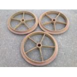 A set of three cast iron railway style wheels with moulded rims, each with five spokes. (23.5in dia)