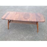 An elm Ercol coffee table, the rectangular rounded top supported on turned tapering angled legs