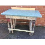 A homemade workbench with rectangular top supported on batton legs.