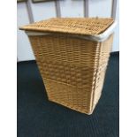 A tapering cane linen basket with hinged lid.