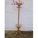 A bentwood hallstand with six scrolled pegs on column, the base with circular ring for sticks