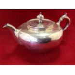 A bun shaped Victorian hallmarked silver teapot, the hinged lid with knob finial, the handle