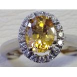An 18ct gold sapphire & diamond cluster ring, the yellow sapphire of over one-and-a-quarter carats