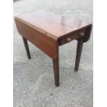 A nineteenth century oak pembroke table, with two rounded drop flaps and cockbeaded frieze drawer