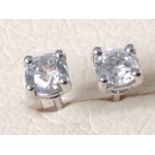A pair of 18ct white gold diamond stud earrings, the round claw set brilliant cut stones