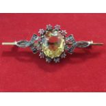 A 9 carat gold Victorian bar brooch, claw set with an oval citrine frame by diamonds with ribbon