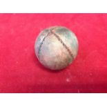An early ball, with four hand-sewn stained leather panels around a wound inner ball. (1.75in)