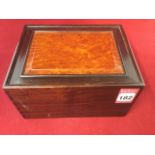 A Chinese hardwood box, having sliding lid with fielded burr panel, the box dovetailed.