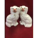 A pair of Victorian Staffordshire wally dogs with painted eyes and pink noses,