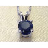 An 18ct white gold sapphire pendant, the single circular claw set stone of approx three-quarters