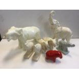 A collection of ceramic elephants, pairs, mainly blanc-de-chine glazed, one grey Spode, and one red