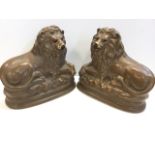 A pair of large Staffordshire style lions, the seated beasts with crossed paws and glass eyes