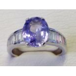 An oval 18ct white gold lilac sapphire and baguette cut diamond ring,