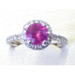 An 18ct gold pink sapphire and diamond cluster ring, the circular claw set stone