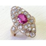 An 18ct gold ruby & diamond cluster ring, the oval rose cut ruby weighing a carat