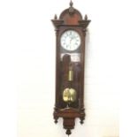 A Victorian rosewood Vienna wallclock, the crest with three turned finials above an arched door