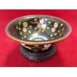 An Edwardian cloisonne bowl raised on tubular foot decorated with flowers