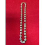 A jade bead necklace, the thirty six hand-knotted graduated stones fitted with 9ct gold