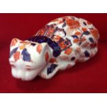 An Imari style cat lying prone and decorated in the brick red & blue floral palette