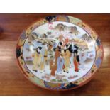 A large nineteenth century Japanese Satsuma charger, the bowl decorated with figures in landscape