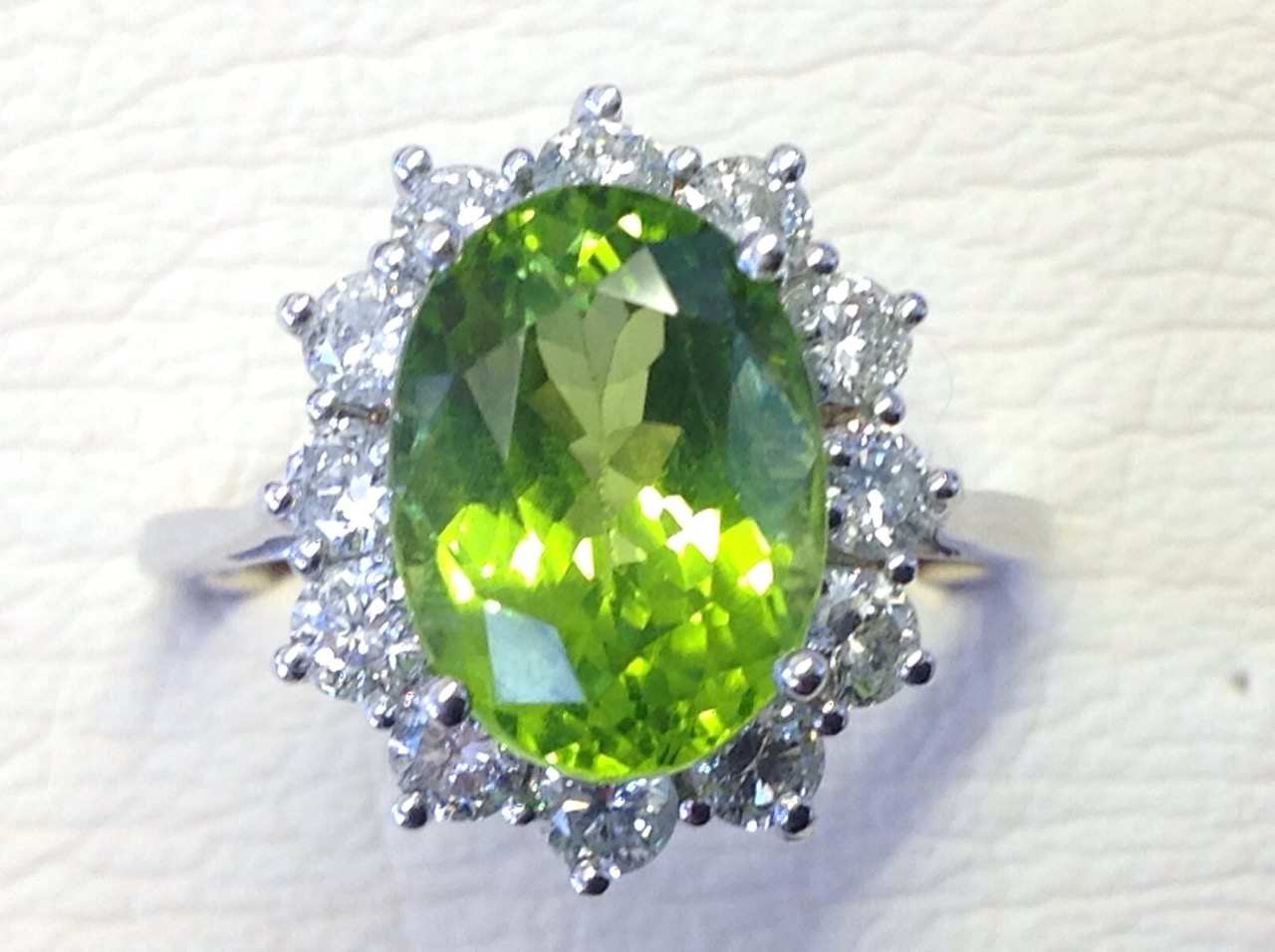 An 18ct diamond and peridot cluster ring, the large green oval stone of over four carats