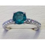 An 18ct gold emerald & diamond ring, the circular claw set emerald stone