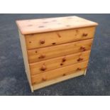 A modern pine chest of drawers with rectangular moulded top above four drawers mounted with knobs,