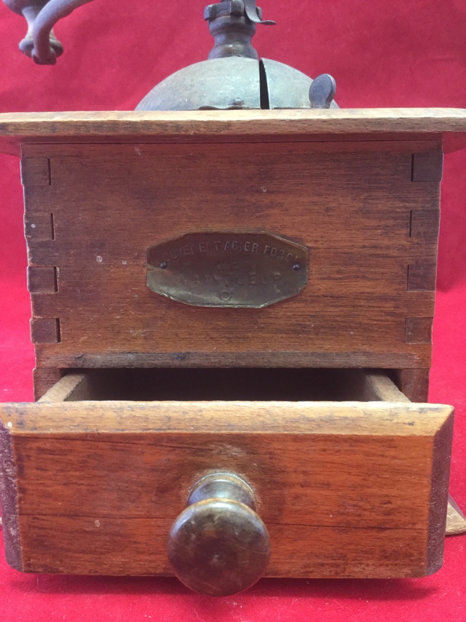 An oak coffee grinder, with crank handle above a domed enclosure, the dovetailed case with knobbed