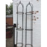 A pair of garden climbing towers of tubular form, bound with metal bands with spear finials. (2)