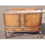 A bowfronted walnut sideboard, the moulded top above central carved panel flanked by panelled