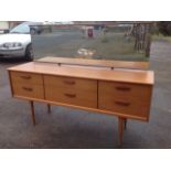 A 70s teak dressing table by F Austin, with rectangular adjustable mirror above a cabinet of six