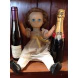 A 60s French Bella girl doll with blue sleep eyes, , and with growler; a bottle of champagne