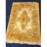 A rectangular rug woven with oval medallion in fawn field framed by golden brown foliate border