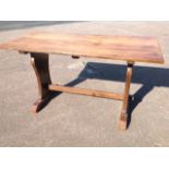 An oak refectory style dining table, with rectangular top on vase shaped supports joined by